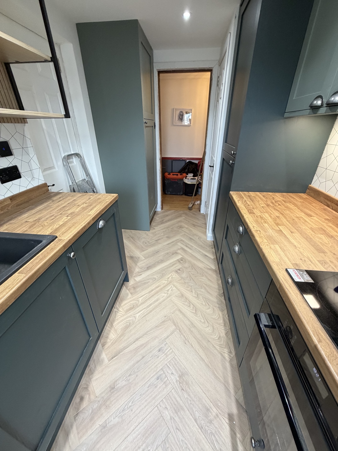 Second view of green shaker cabinetry and timber worktops